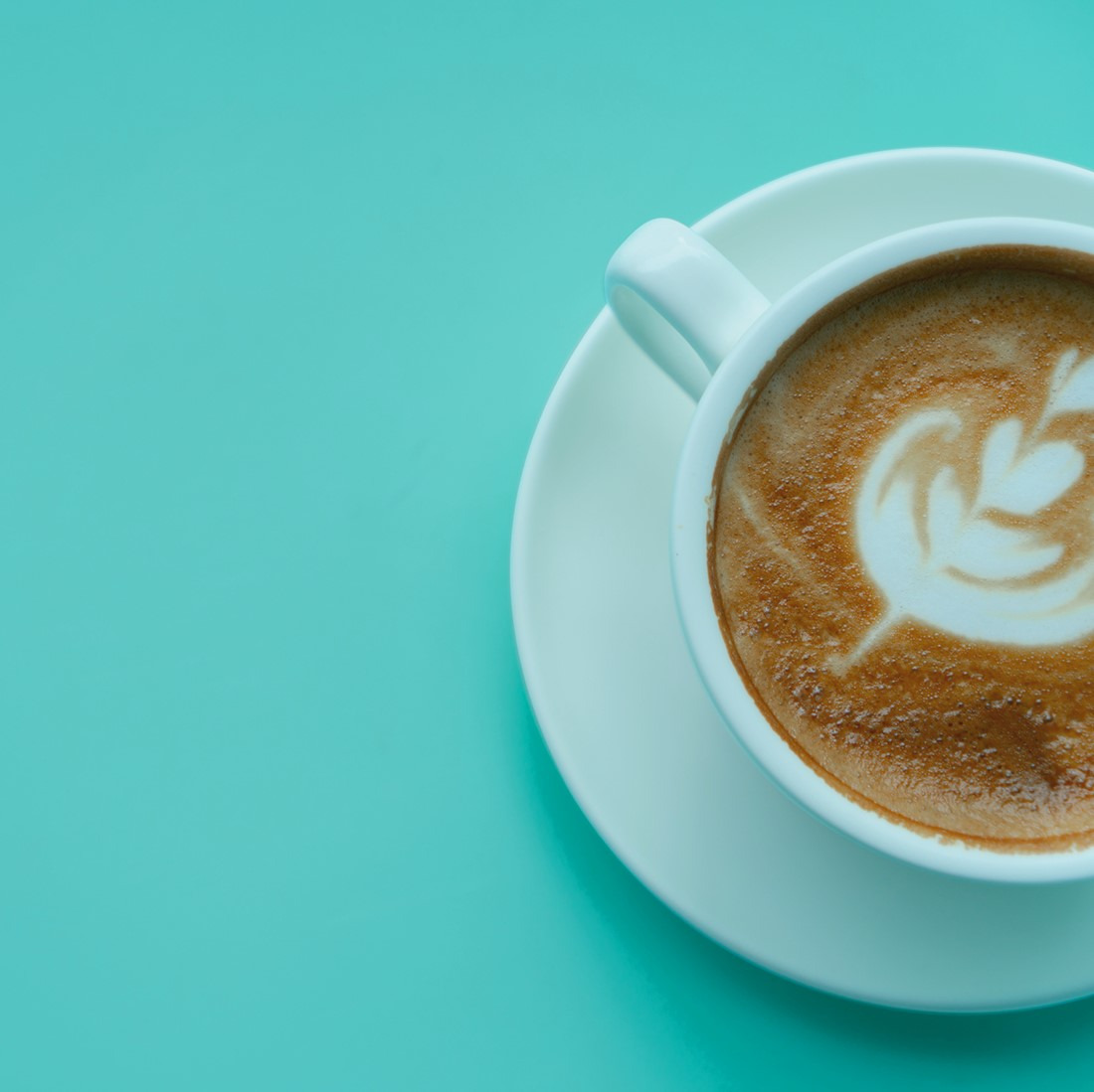picture of a latte on a teal background